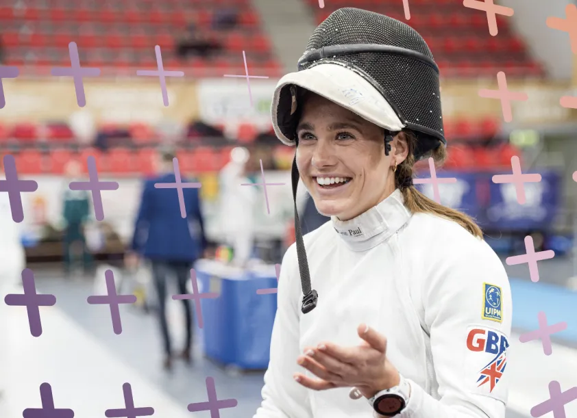 Pentathlon GB athlete smiling in fencing gear during a competition