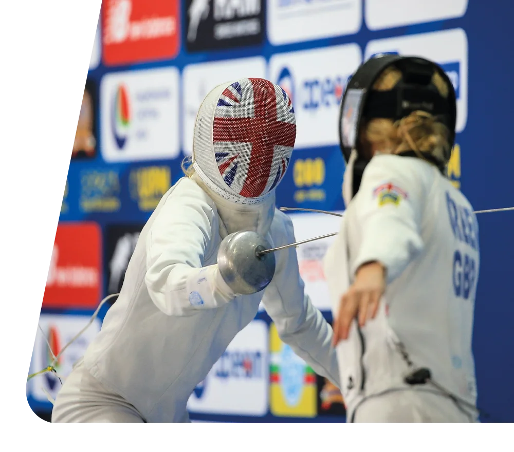 Pentathlon GB athlete in fencing gear with a Union Jack mask during a competition